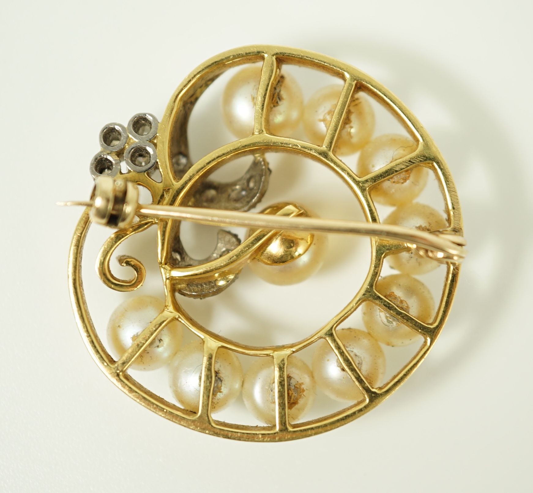 A 20th century gold, cultured pearl and diamond set open work scroll brooch